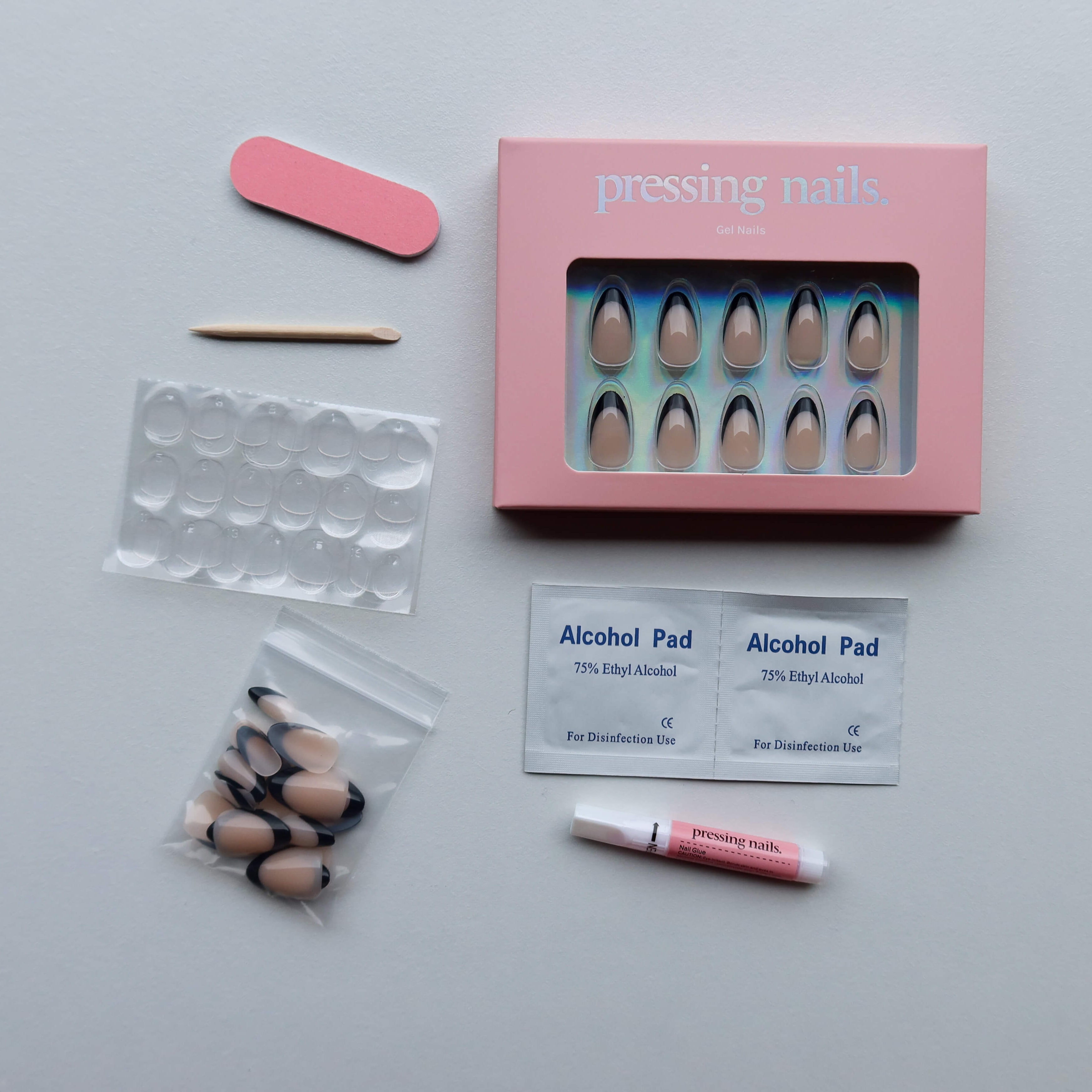 Manicure press on nail kit , alcohol pads, and a pink box on a white background