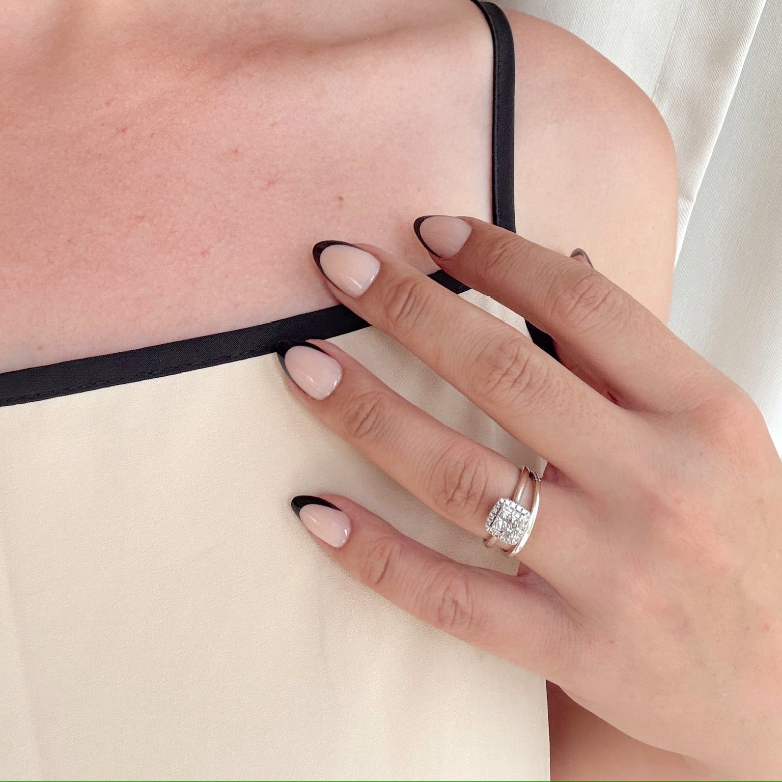 A hand with black-tipped gel press on nails.
