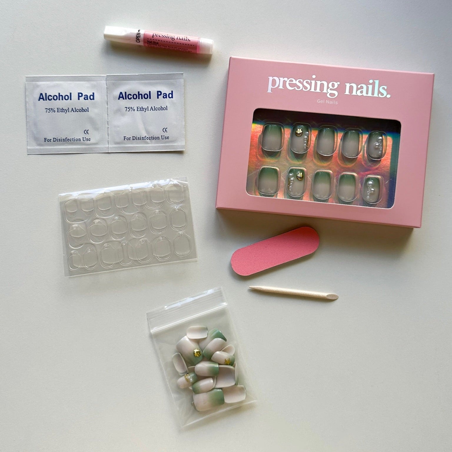 Nail pressing kit with tools and nail forms on a white surface